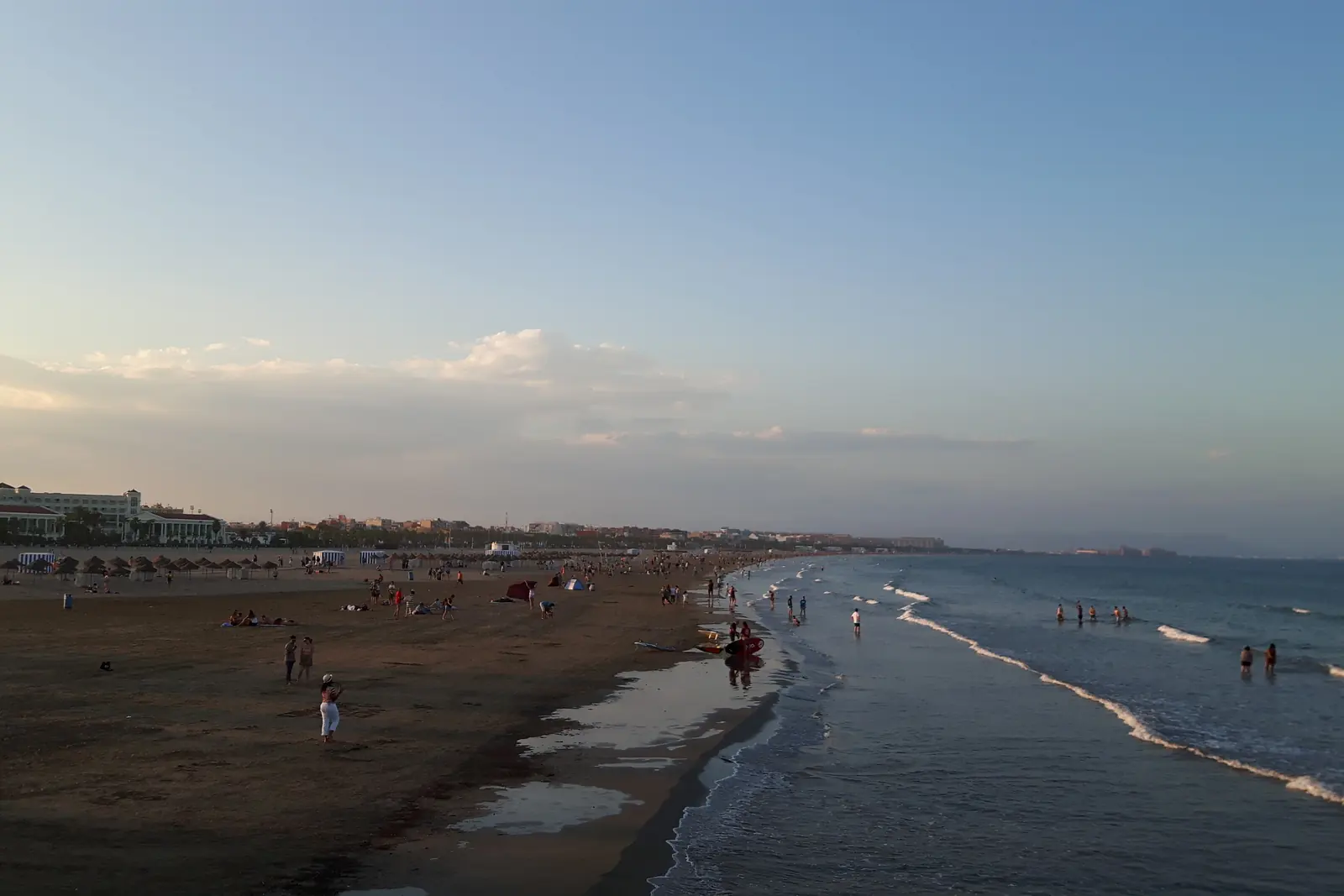 Malvarrosa Beach in Valencia at dusk, with the sea washing the sand and the hotels along the shore